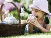 Niña comiendo un huevo de pascua. Tarjeta virtual para los niños