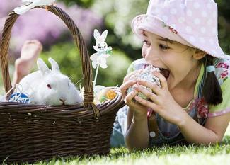 Niña comiendo un huevo de pascua. Tarjeta virtual para los niños