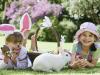 El conejo de Pascua y dos niñas. Tarjeta virtual para los niños