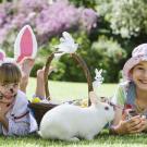 El conejo de Pascua y dos niñas. Tarjeta virtual para los niños