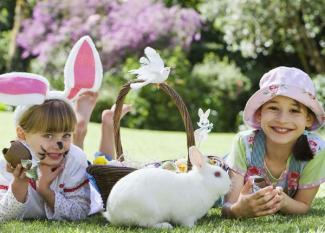 El conejo de Pascua y dos niñas. Tarjeta virtual para los niños