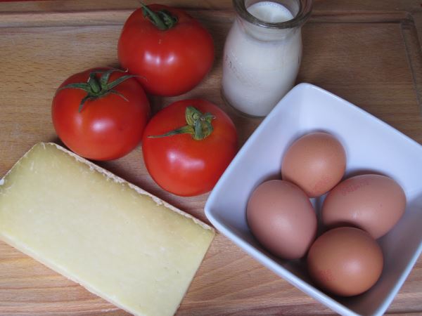 Receta infantil de huevos al plato con tomate y queso comte paso 1